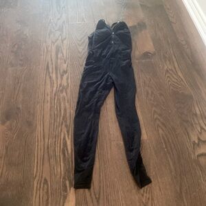 Black cross back jumpsuit with mesh paneling on legs.